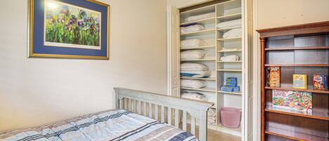 A bedroom with a bed, a wardrobe, and a bookshelf.