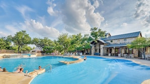 Una piscina con un edificio de fachada de piedra al fondo.