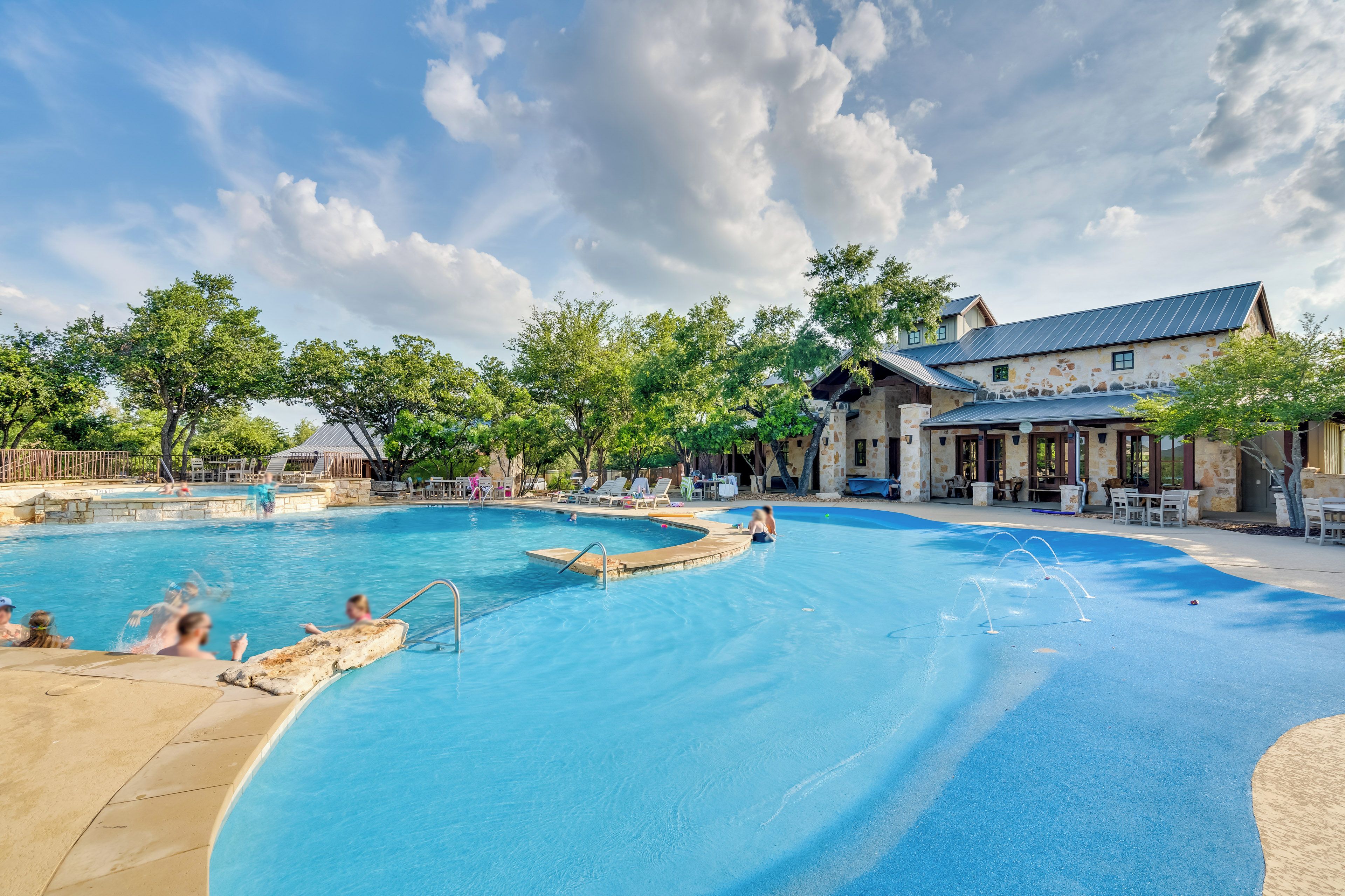A swimming pool with a stone facade building in the background.