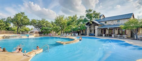Una piscina con un edificio de fachada de piedra al fondo.