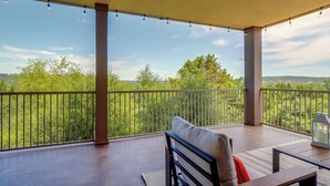 Un espacio al aire libre techado con vistas a zonas verdes y colinas.