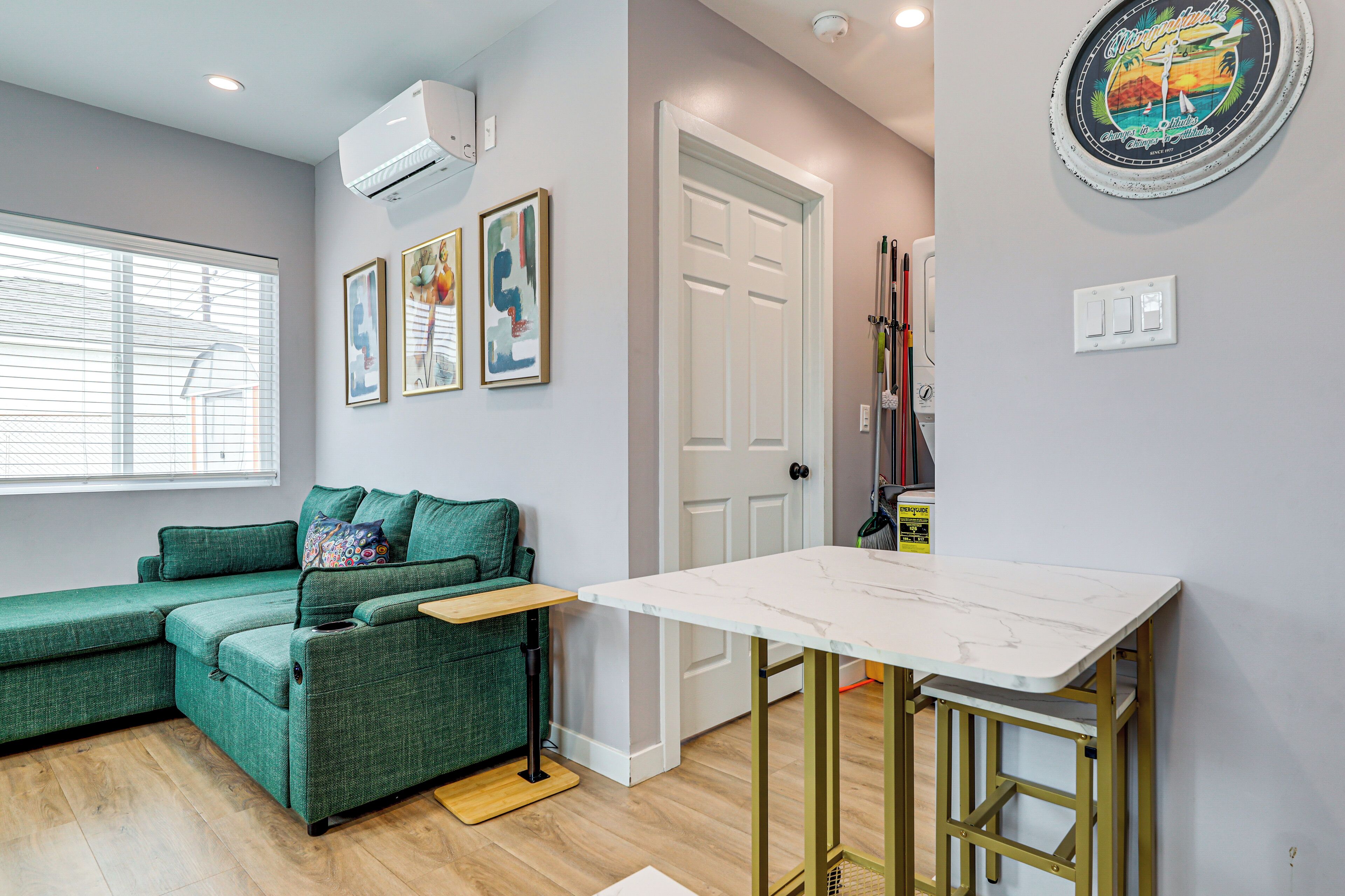 A modern living space with a green sofa, a small table, and a white door.