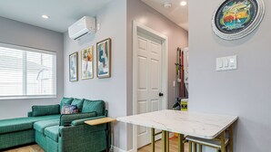 A modern living space with a green sofa, a small table, and a white door.
