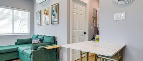 Un espace de vie moderne avec un canapé vert, une petite table et une porte blanche.