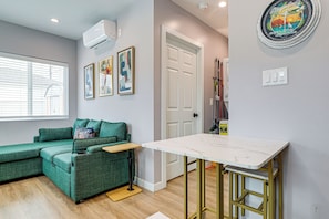 A modern living space with a green sofa, a small table, and a white door.