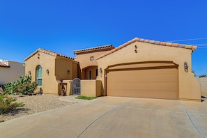 A single-story house with a garage, a small entryway, and a landscaped front yard. - Las Cruces Oasis: Patio, Hot Tub + Mtn Views (Las Cruces)