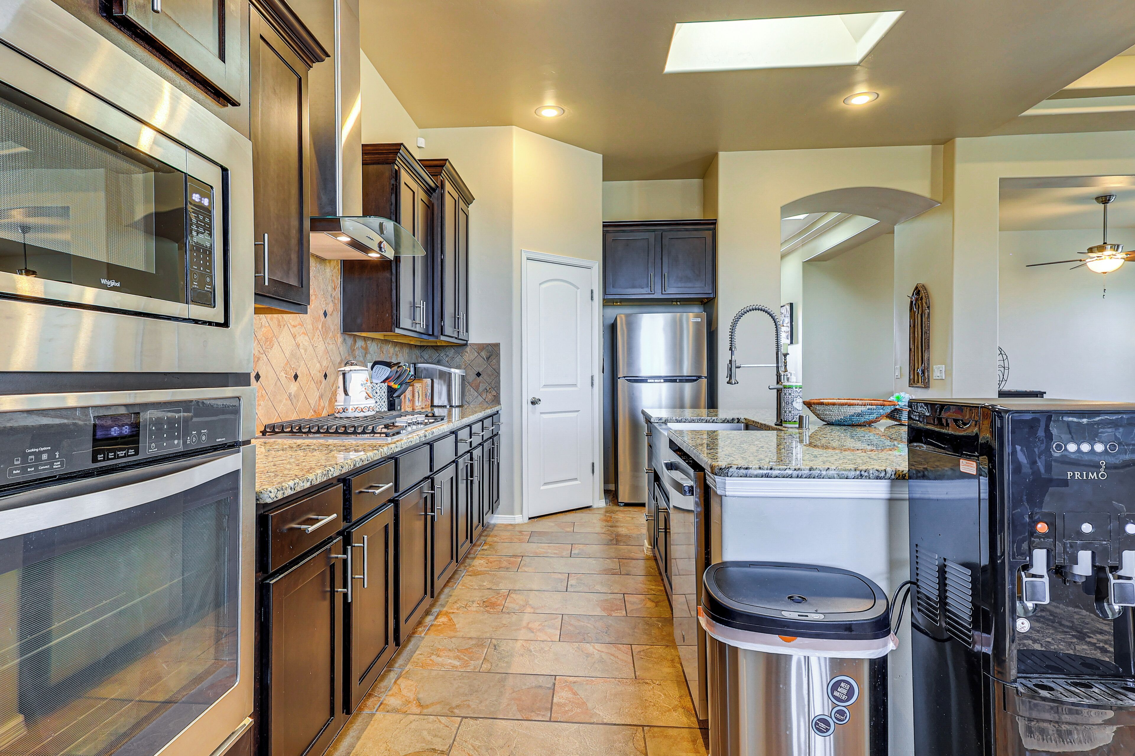 A modern kitchen with stainless steel appliances, a granite countertop, and a built-in oven.