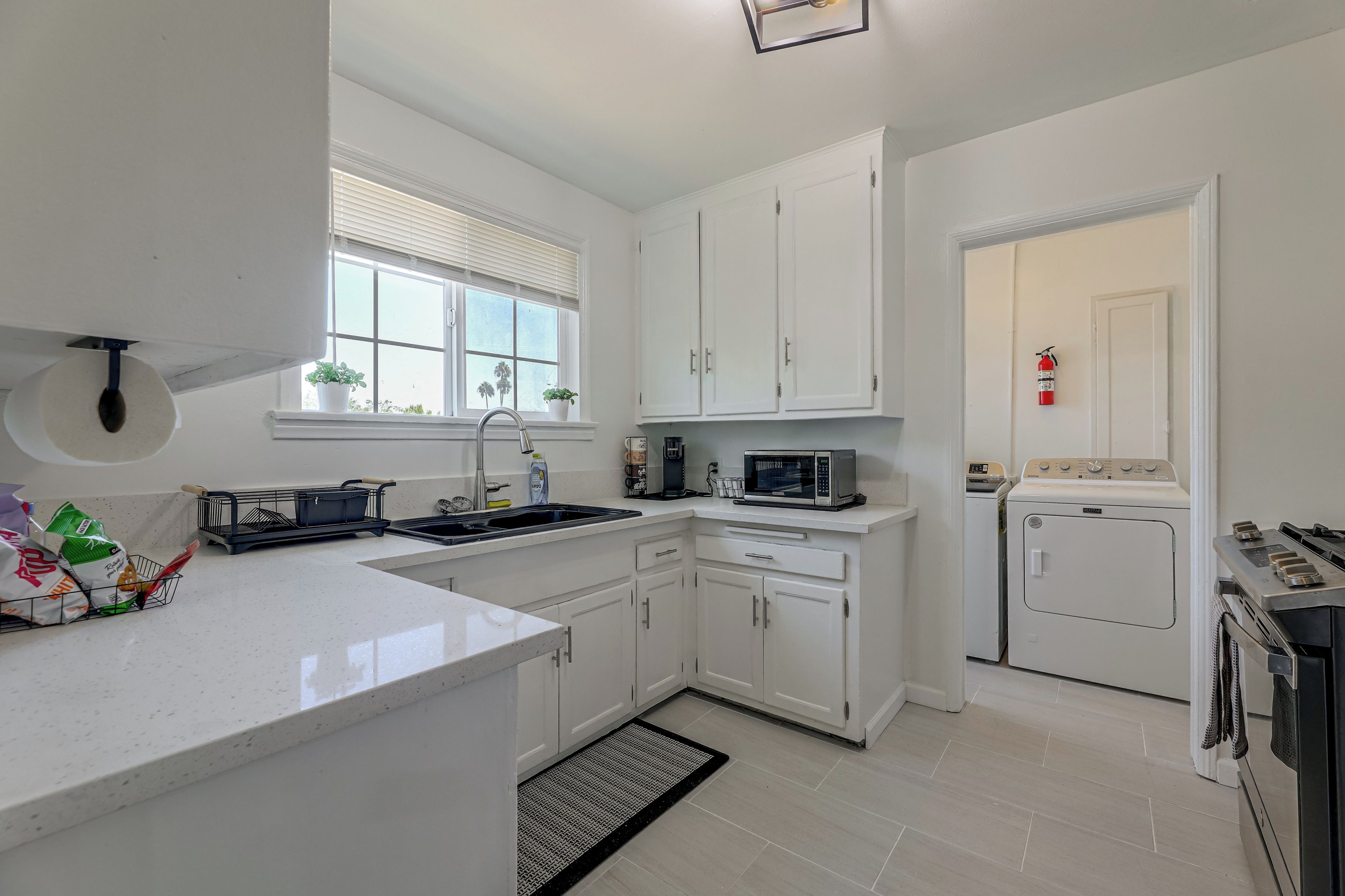 A modern kitchen with white cabinetry, a built-in microwave, and a stove.