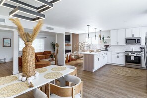 A modern kitchen with white cabinetry, a built-in microwave, and a stainless steel range.