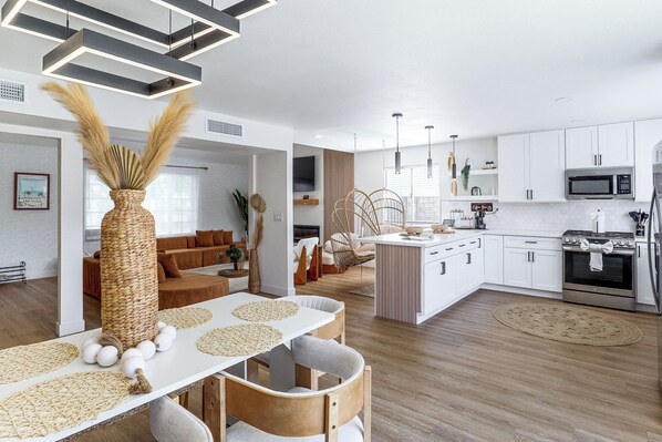 A modern kitchen with white cabinetry, a built-in microwave, and a stainless steel range.