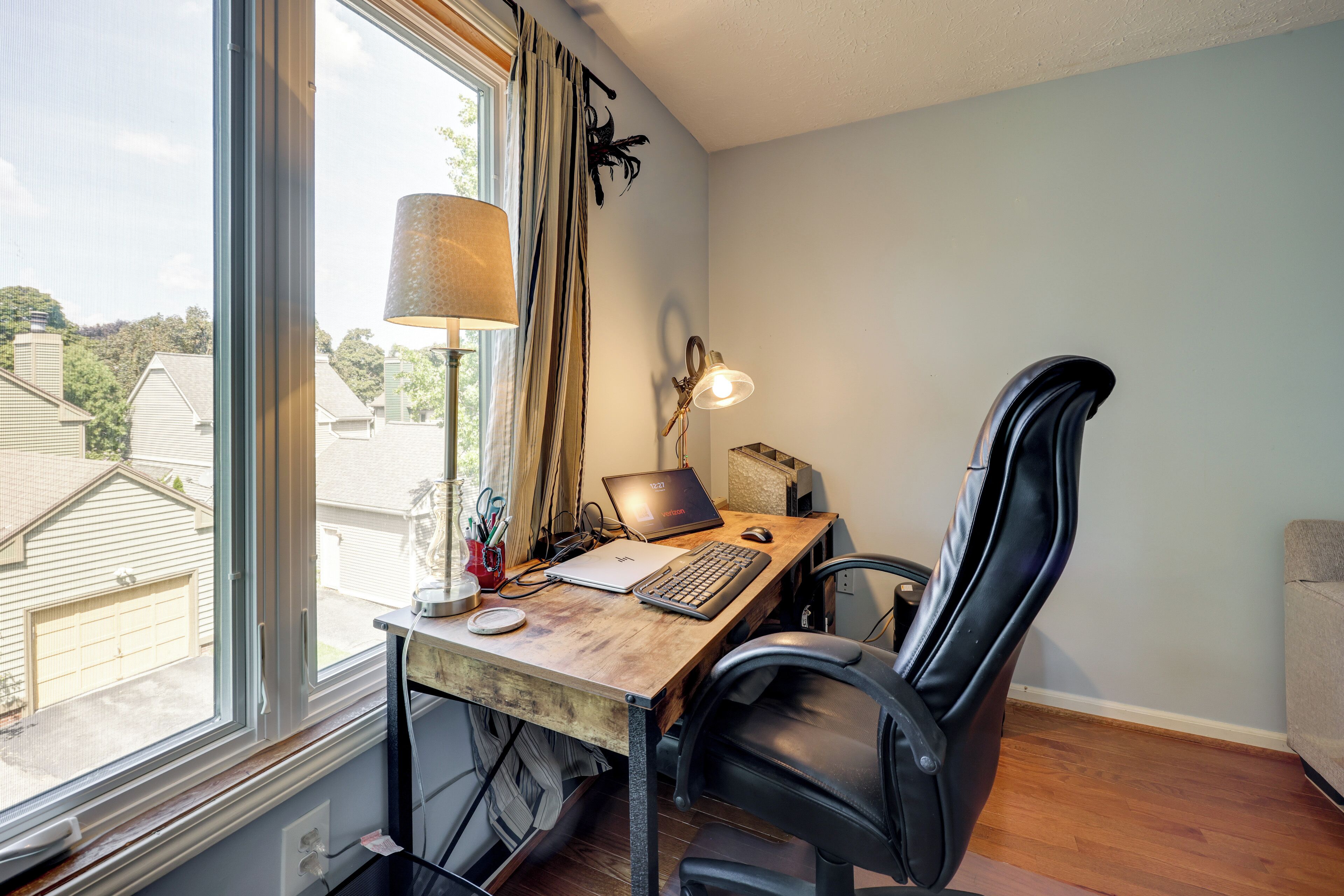 Una oficina en casa con escritorio, ordenador portátil, teclado, ratón y silla.