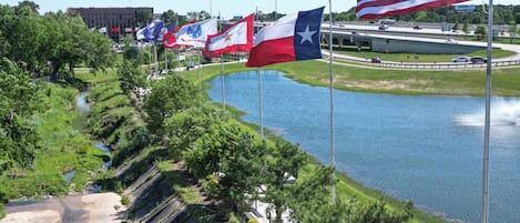 Une rivière bordée de drapeaux, un pont et un bâtiment en arrière-plan.