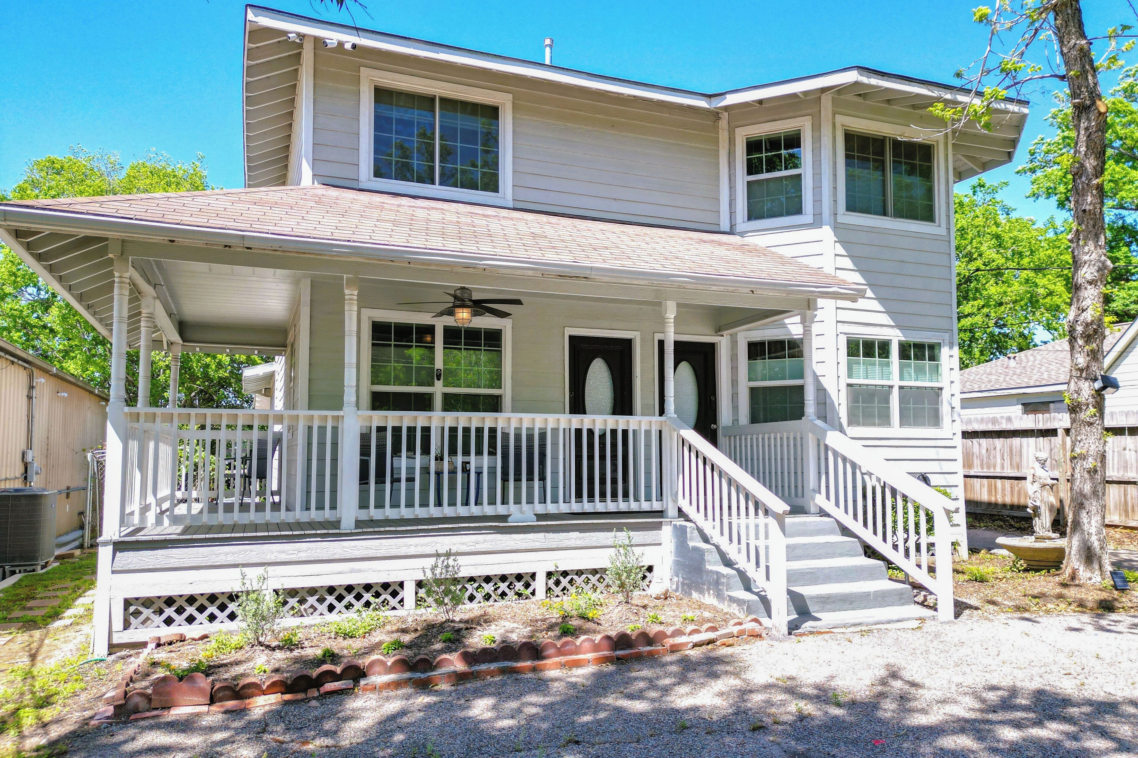 A two-story house with a porch, a covered front entrance, and a staircase leading to the main door.