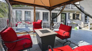 An outdoor patio with red chairs and a table, overlooking a residential area. - Group Getaway w/ Lake Views in Bronston! (Bronston)