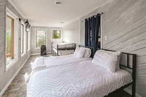 A bedroom with a large bed, a desk, and a window with curtains. - Group Getaway w/ Lake Views in Bronston! (Bronston)