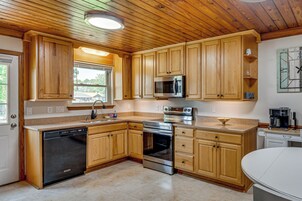 A kitchen with wooden cabinets, a dishwasher, a microwave, an oven, and a coffee maker.