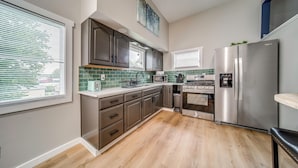 A modern kitchen with a built-in oven, microwave, and stainless steel refrigerator. - Family Fun! Indoor Jungle Gym, Hot Tub & Beach (Erie)