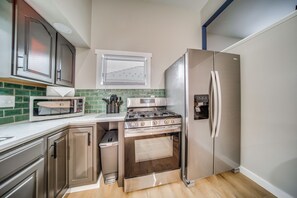 A compact kitchen with a built-in microwave, stove, and refrigerator. - Family Fun! Indoor Jungle Gym, Hot Tub & Beach (Erie)