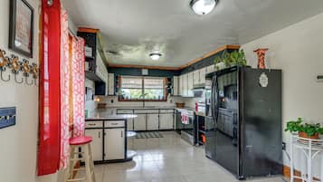 A kitchen with a refrigerator, stove, and sink.