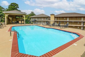A rectangular swimming pool with a red brick border, surrounded by lounge chairs and a covered seating area. - Lakefront, Pool & Dock Access! Hot Springs Gem (Hot Springs)