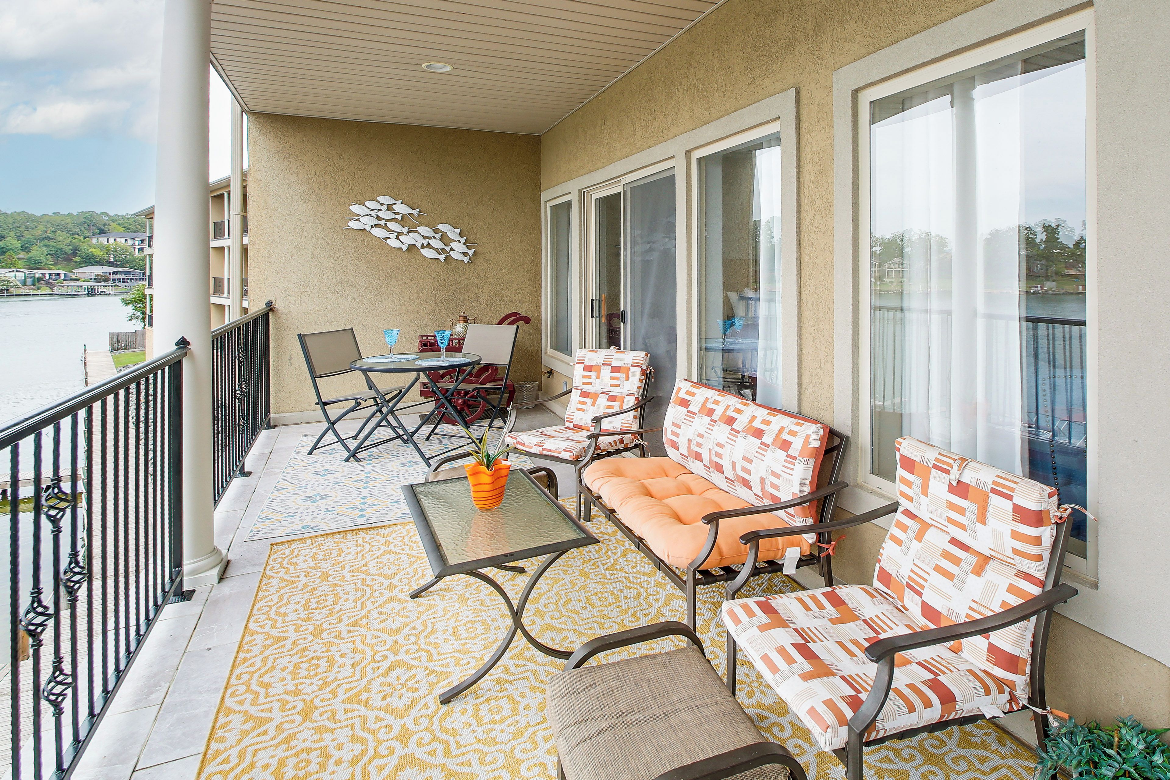 Een balkon met een tafel, stoelen en een bank.