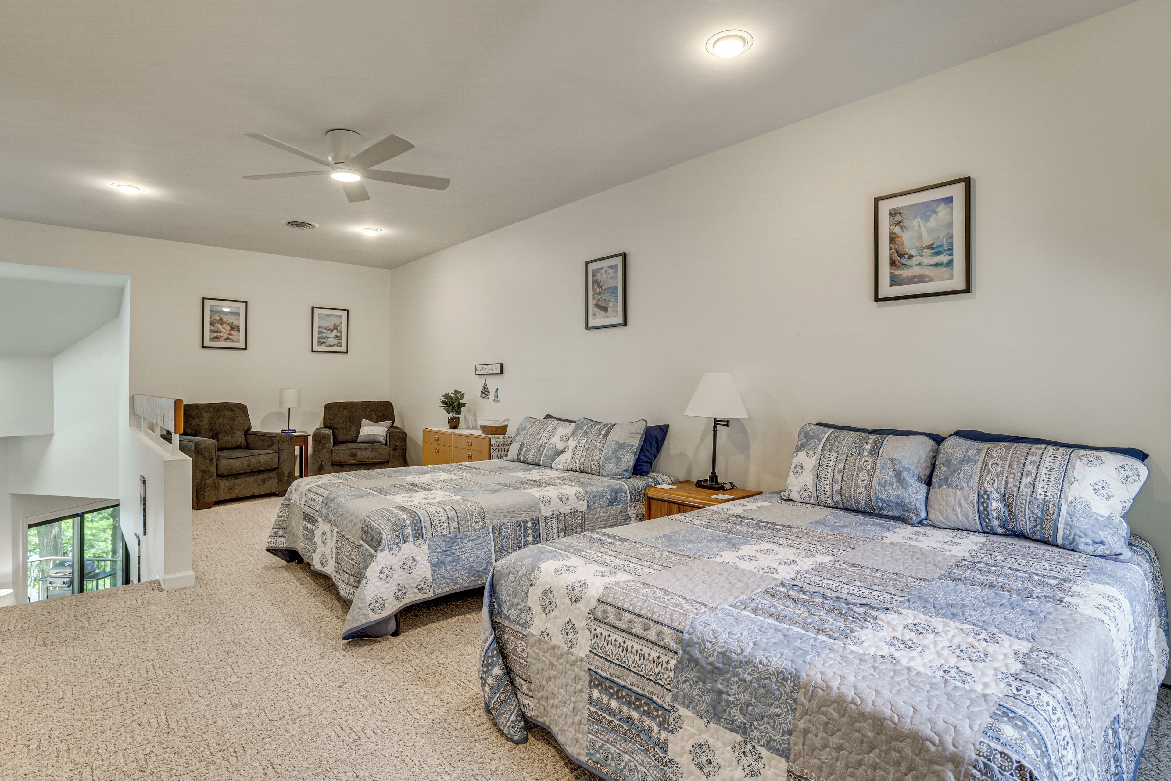 A bedroom with two beds, a ceiling fan, and artwork on the walls.
