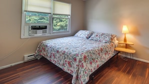 Una camera da letto con un letto, un comodino, una lampada e una finestra con persiane.