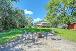 A backyard with a fire pit, two chairs, and a house in the background. - Centrally Located Adventure Basecamp in King! (King)