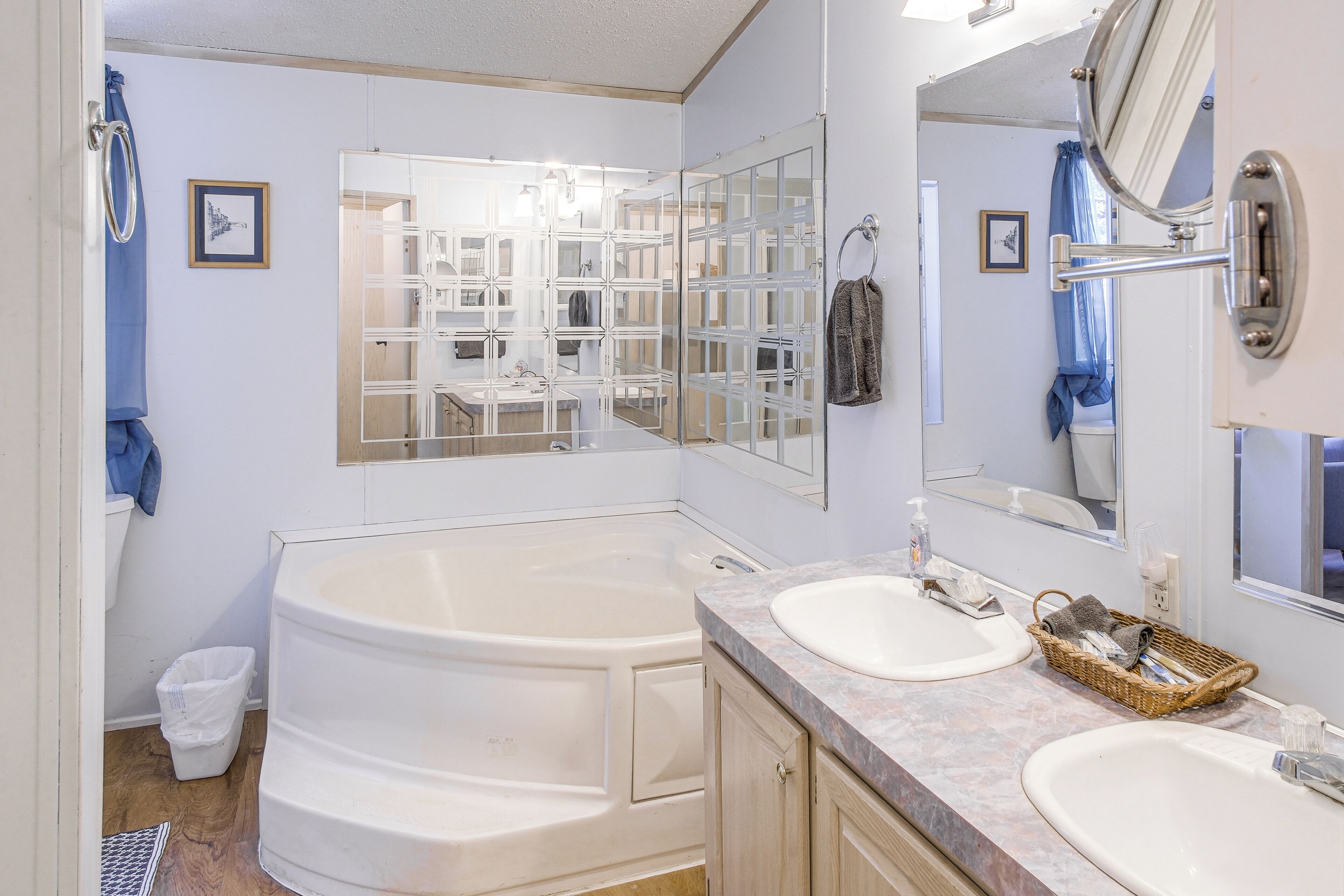 A bathroom with a large bathtub, two sinks, and a mirror.