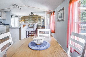 A dining area with a wooden table, chairs, and a ceiling fan. - Fishing Pond & Patio Near Lake Texoma! (Kingston)