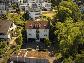 A multi-story residential building with a sloped roof, a central entrance, and a small parking area. - Nagold Quartier (Nagold)