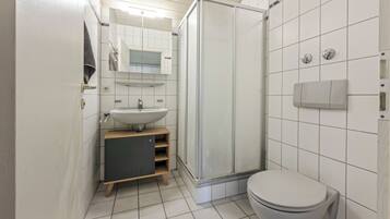 Un bagno con servizi igienici, lavandino e doccia.