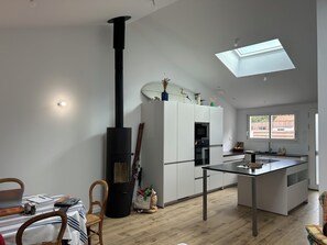 Una cocina moderna con una isla central, estufa integrada y tragaluz.