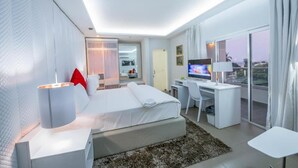 Una habitación de hotel moderna con cama, escritorio y televisor.