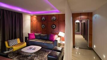 Een moderne woonkamer met een bank, salontafel en een lamp.