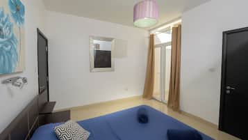 Une chambre à coucher avec un lit, un miroir, une douche et une porte.