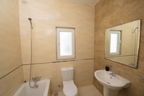 Une salle de bain avec une baignoire, des toilettes et un lavabo.
