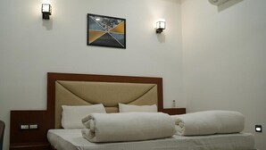 Een hotelkamer met een bed, nachtkastjes en wandlampen.