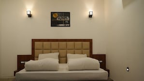 Een slaapkamer met een groot bed, twee nachtkastjes en wandlampen.