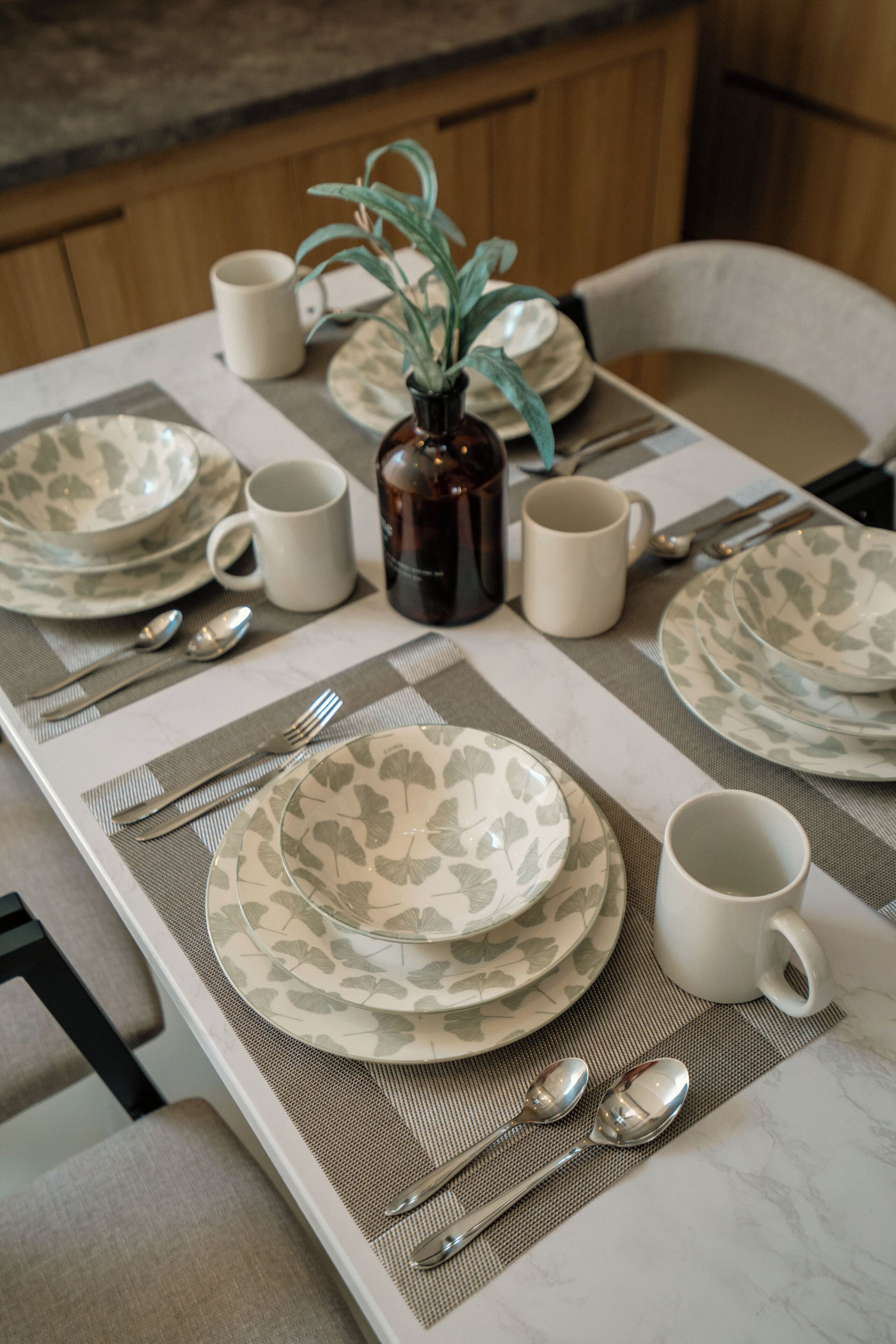 Una mesa de comedor servida con platos, vasos y cubiertos.
