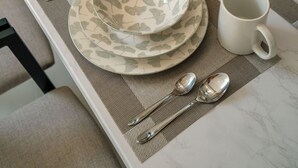 A dining table set with plates, cups, and cutlery. - Villa Lopina Umalas (Kuta Utara)