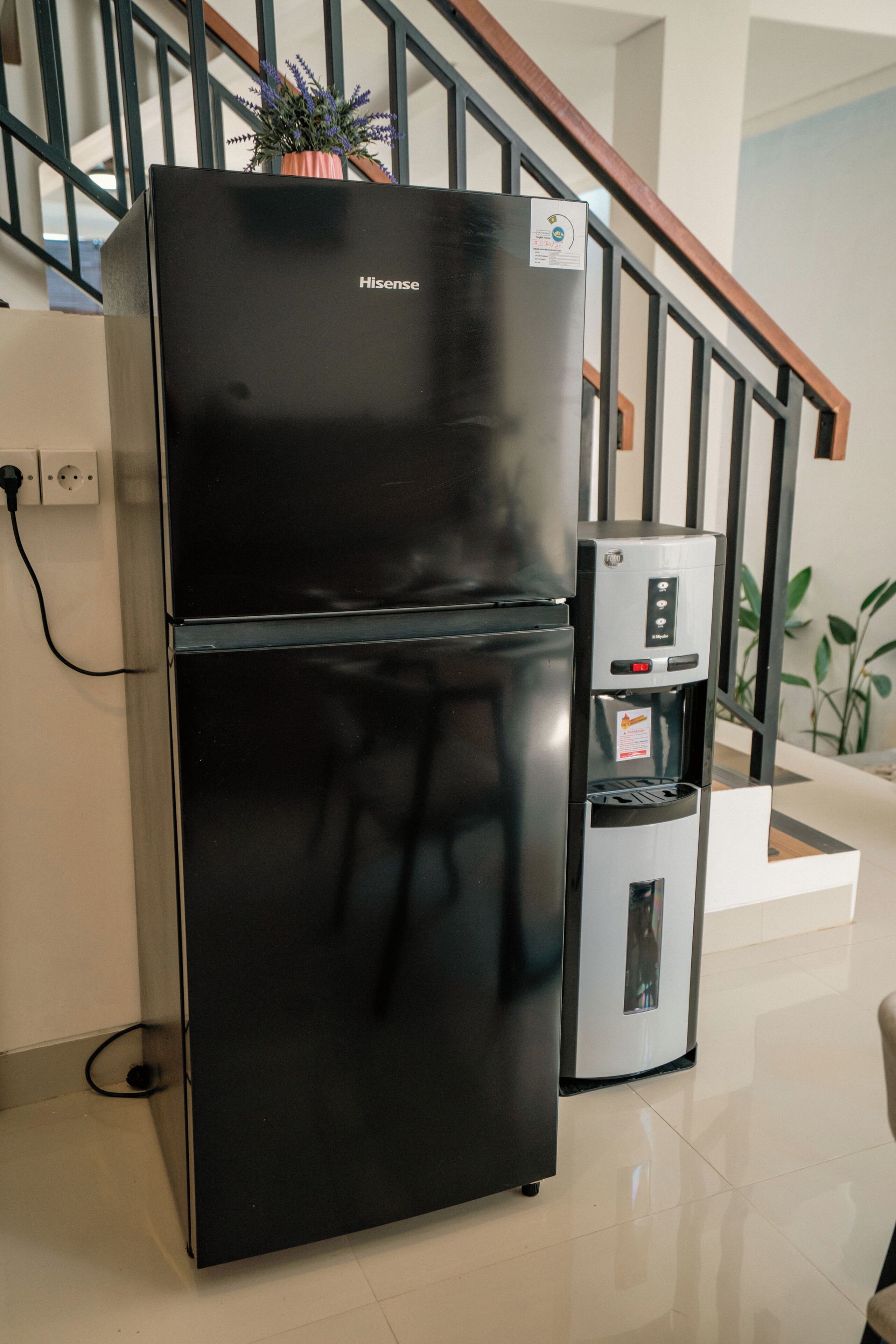 Un refrigerador negro con dispensador de agua y el logotipo de Hisense.