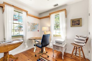 A room with a desk, chair, printer, and a map on the wall. - Blue Water Cottage | Porch, Courtyard, Office by Lucky Savannah (Savannah)