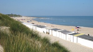Una spiaggia con edifici bianchi, una riva sabbiosa e l'oceano.