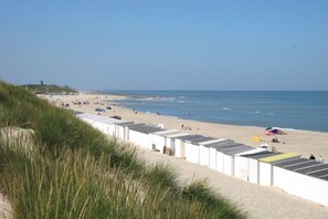 A beach with white buildings, a sandy shore, and the ocean. - Holiday home with 3 bedrooms (Oostkapelle)