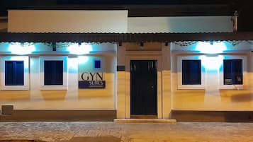 Un edificio con un cartel que dice 'GYN SUITES UNIVERSITY', indicando que es alojamiento universitario.