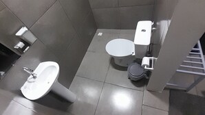 A small, modern bathroom with a toilet, bidet, and sink.