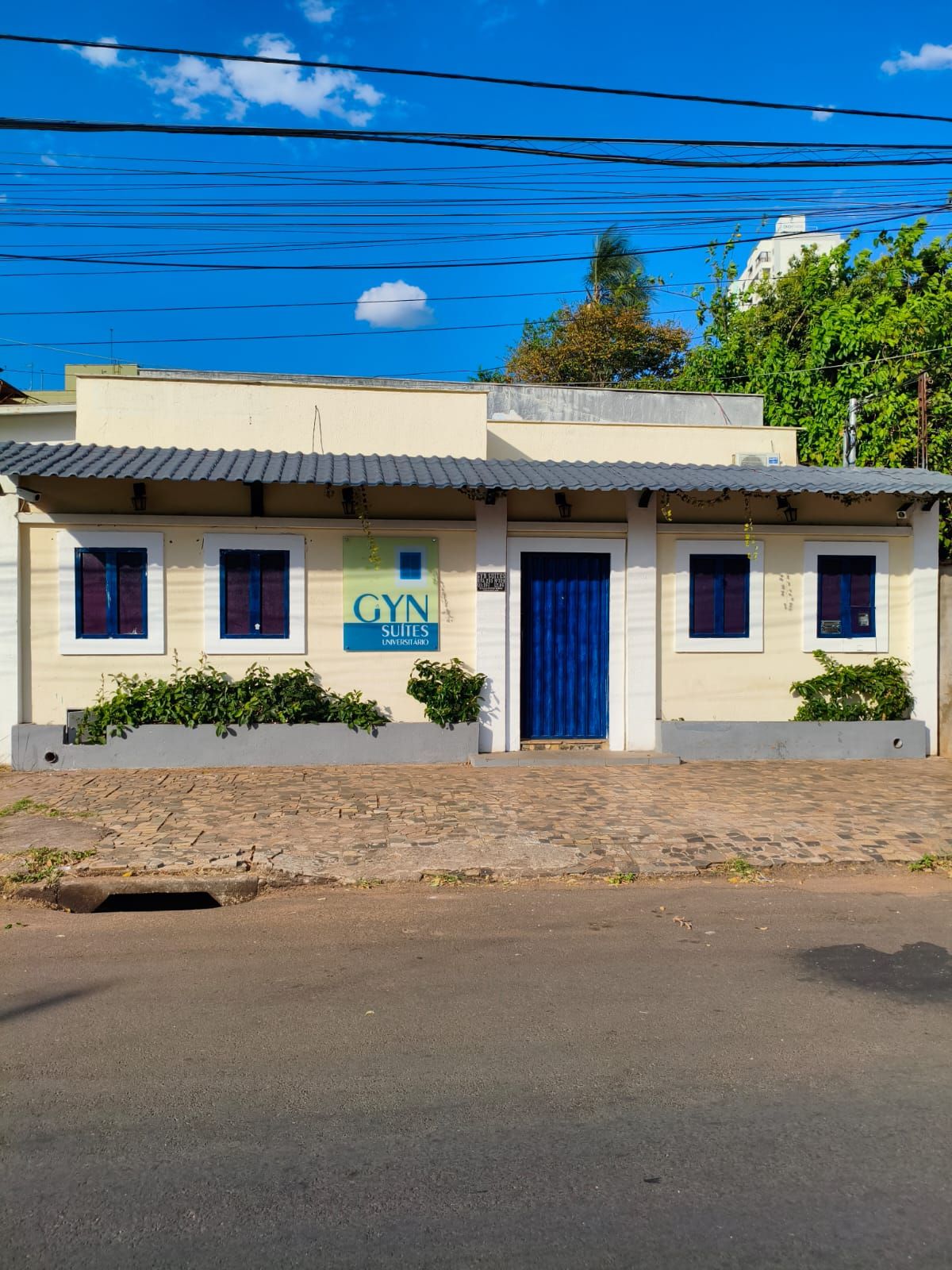 Un edificio con un letrero que indica 'GYN SUITES (UNIVERSITY)', señalando que se trata de un alojamiento universitario.