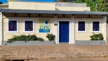 Un edificio con un letrero que indica 'GYN SUITES (UNIVERSITY)', señalando que se trata de un alojamiento universitario.