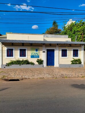 Un edificio con un letrero que indica 'GYN SUITES (UNIVERSITY)', señalando que se trata de un alojamiento universitario.